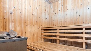 A sauna room with wooden benches and a stone heater. - Vibrant Holiday Home in RÃ¸mÃ¸ near Sea (Rømø)
