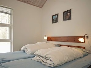 Cozy retreat with a single bed, bedside lamps, and a large window.