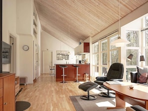 Relax in this inviting living area with a high ceiling, comfortable seating, and a dining table.