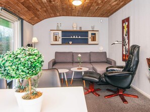 A modern living room with a grey sofa, a black leather chair, and a small coffee table. - 4 Person Holiday Home in Grindsted-by Traum (Grindsted)