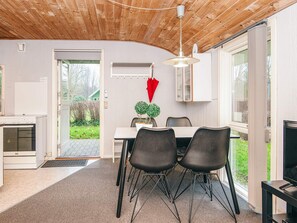 A modern kitchen with a built-in oven, a dining area with a table and chairs, and a view of the outdoors. - 4 Person Holiday Home in Grindsted-by Traum (Grindsted)