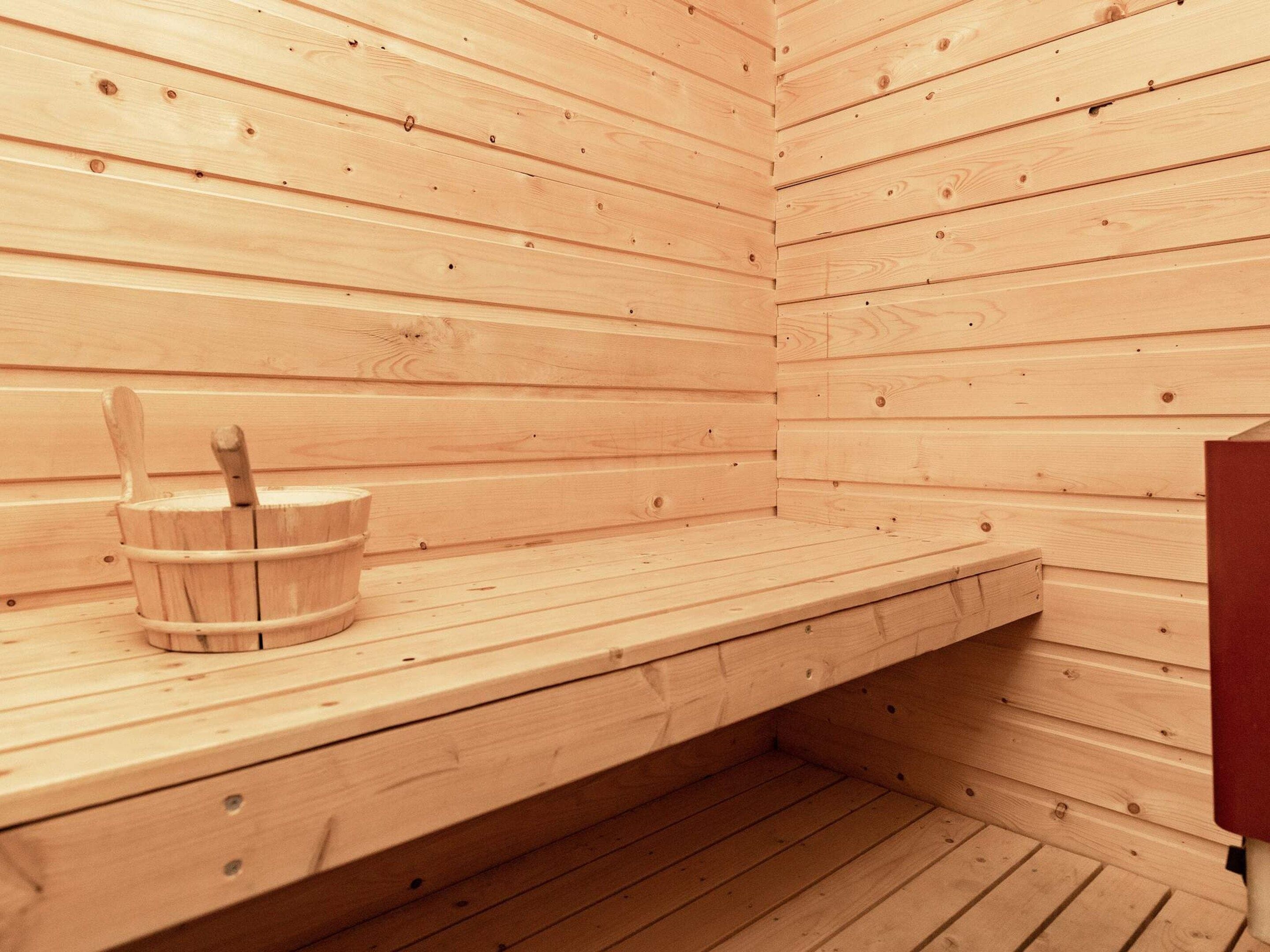 En sauna med trævægge og en bænk.