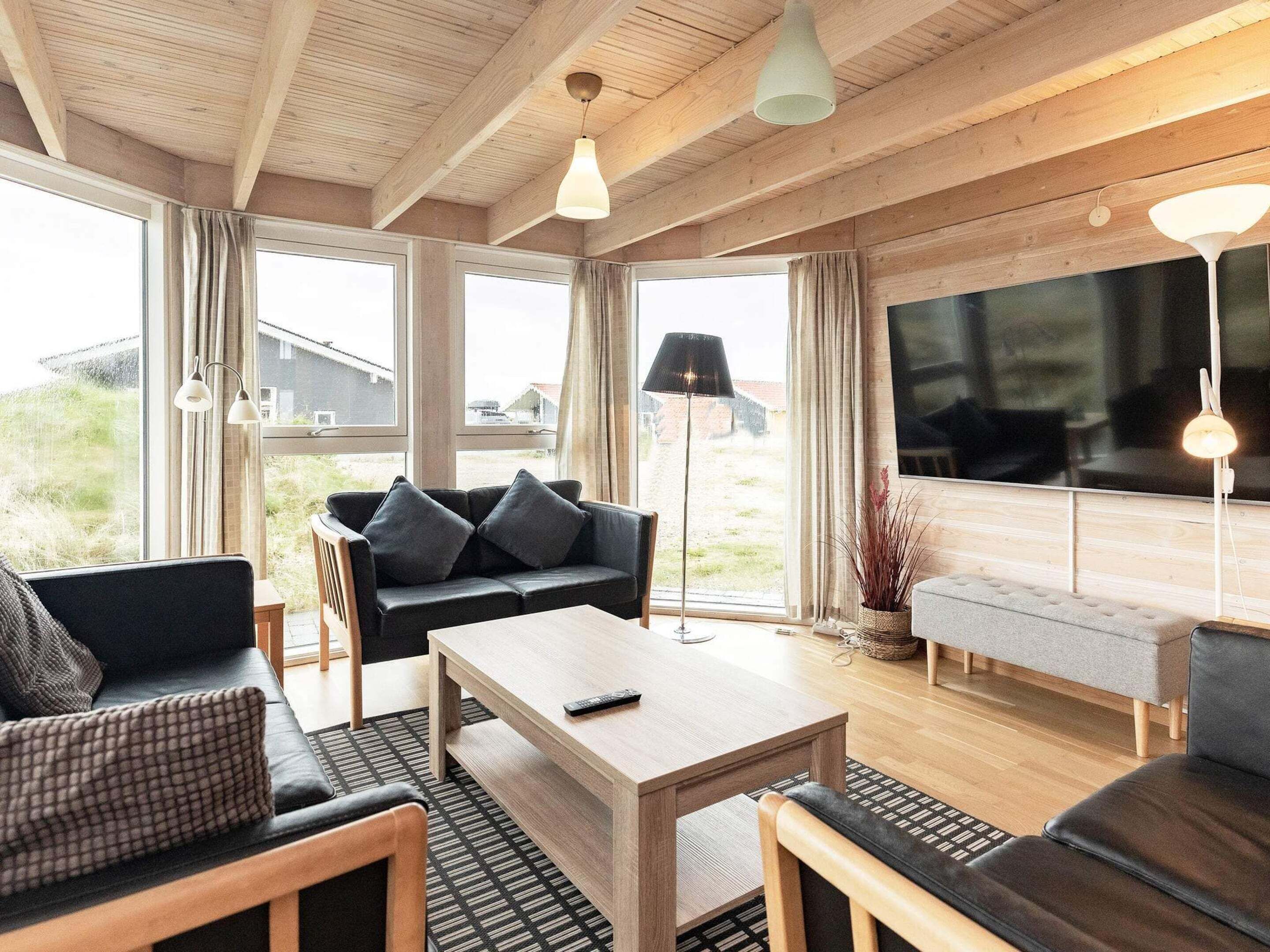 A modern living room with a sofa, a coffee table, and a TV.
