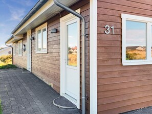 A wooden house with a number 31 on the side, a door, and a window.