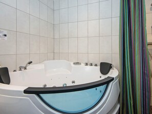 A modern bathroom with a freestanding bathtub, a shower curtain, and tiled walls. - 5 Star Holiday Home in Romo (Rømø)