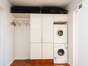 A laundry room with stacked luggage, a drying rack, and two washing machines. - 5 Star Holiday Home in Blavand (Blavand)