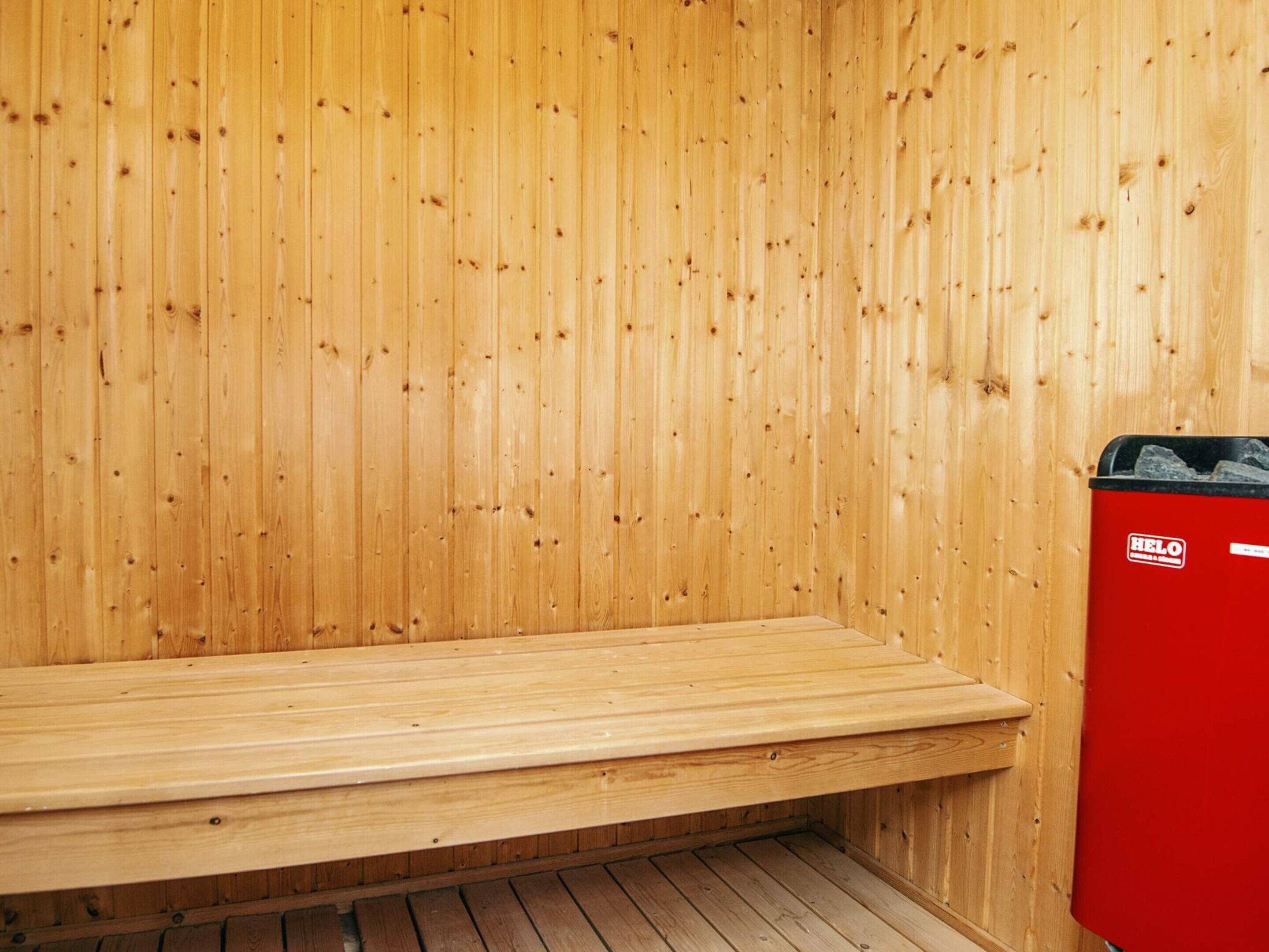A sauna with wooden walls and a bench.