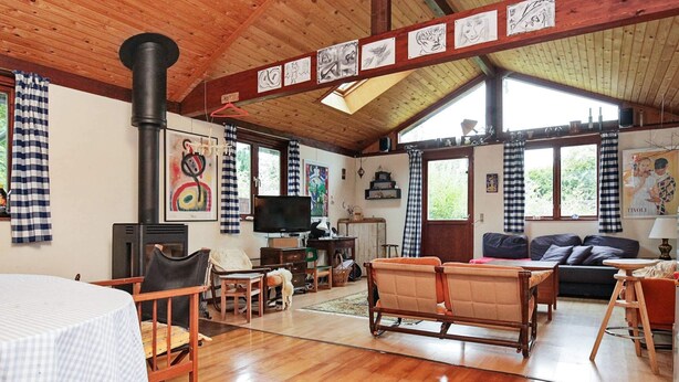 A spacious living room with wooden floors, a fireplace, a sofa, and a television. - Holiday Home in Nykøbing Sjælland near Sea (Nykobing Sjaelland)