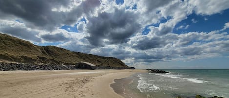 A beach with a rocky shoreline and waves.