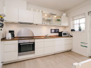 A modern kitchen with white cabinetry, stainless steel appliances, and a wooden countertop. - Cozy Holiday Home in Nykobing Sjaelland near Fishing Village (Nykobing Sjaelland)