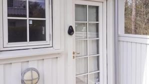 A white building with a window, a door, and a small circular window. - Cozy Holiday Home in Nykobing Sjaelland near Fishing Village (Nykobing Sjaelland)