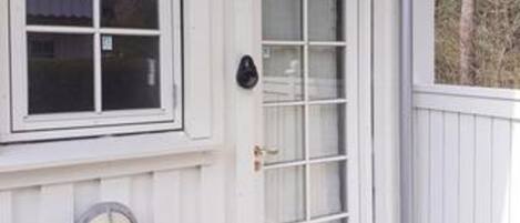 Un bâtiment blanc avec une fenêtre, une porte et une petite fenêtre ronde.