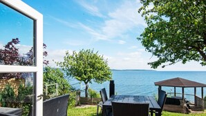 A deck with a table and chairs, overlooking a body of water. - Panoramic Retreat by Water (Borkop)