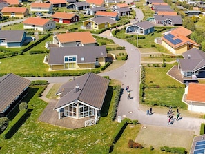 A residential area with houses, a central road, and a large building with a glass facade. - Holiday Home in Grömmitz (Groemitz)