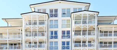 Um hotel com vários andares, varandas e grandes janelas.