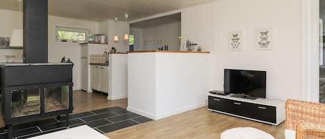 Una sala de estar moderna con chimenea, televisor y comedor.