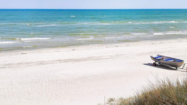 En strand med en båt på sanden.