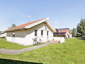 En enplansbyggnad med ett sluttande tak, en satellitantenn och en cykel som står parkerad utanför.
