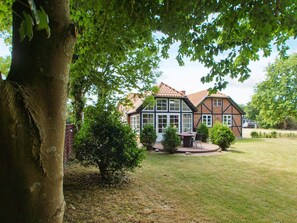 A traditional house with a large front lawn, a patio area, and a tree in the foreground. - 4 Star Holiday Home in Hemmet (Hemmet)