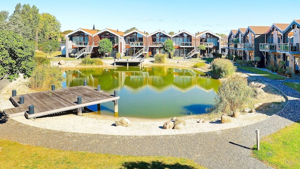 A lakeside hotel with multiple buildings, a dock, and a pond. - 4 Person Holiday Home in Bogense-by Traum (Bogense)