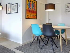 Een eethoek met een tafel, stoelen en een hanglamp.