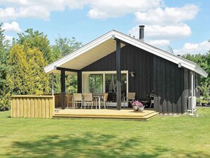 A modern wooden cabin with a covered patio, outdoor seating, and a chimney. - 6 Person Holiday Home in Ansager-by Traum (Ansager)