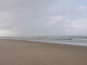 A beach with a wide sandy shore and waves approaching the beach. - Beautiful Holiday Home in Vejers Strand with Hot Tub (Vejers Strand)