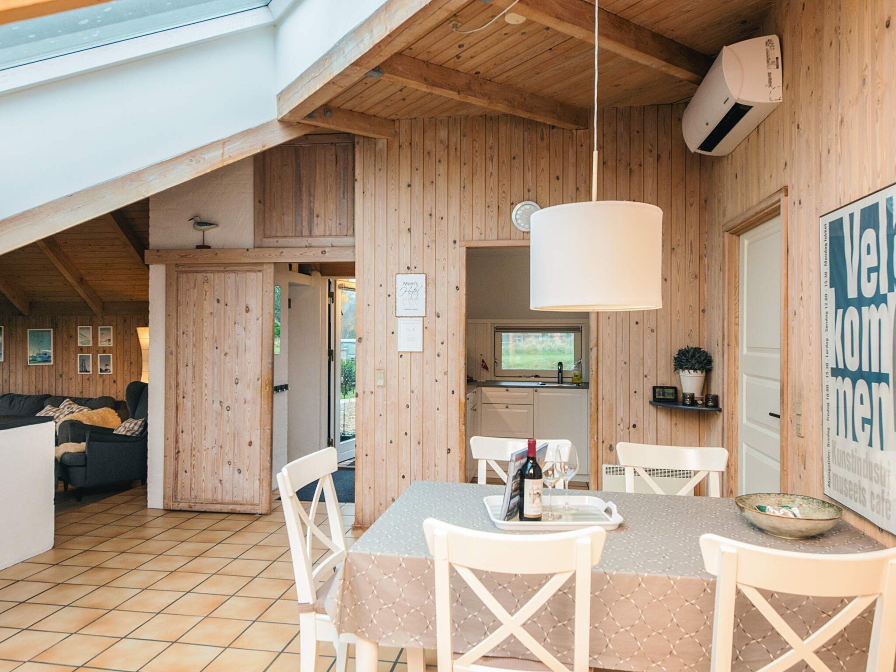 Un interior de madera con comedor, cocina y sala de estar.