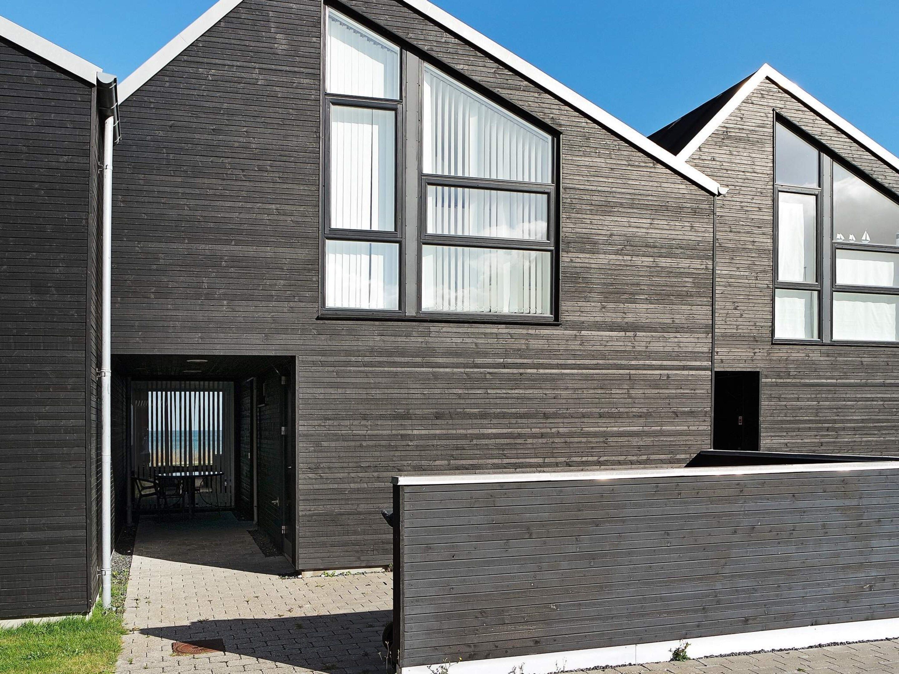 Un bâtiment moderne doté d’un toit en pente, de grandes fenêtres et d’une entrée de plain-pied.