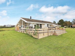 A modern house with a large deck, a covered outdoor area, and a grassy yard. - 9 Person Holiday Home in Millinge (Millinge)