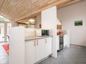 A modern kitchen with white cabinetry, a microwave, and an oven. - 4 Star Holiday Home in Hjorring (Hjørring)
