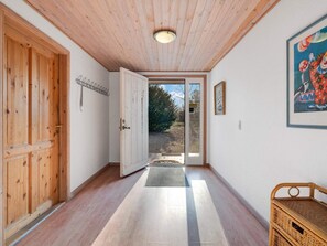 A hallway with wooden doors, a mat at the entrance, and a framed picture on the wall. - 12 Person Holiday Home in Nordborg (Nordborg)