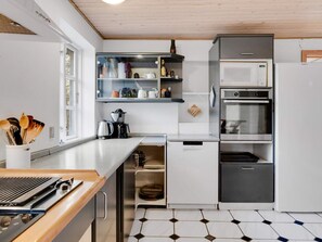 A modern kitchen with a built-in microwave, oven, and coffee maker. - 12 Person Holiday Home in Nordborg (Nordborg)