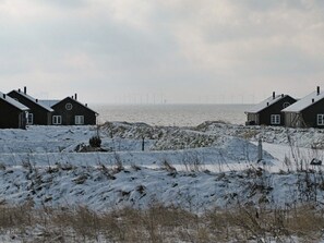 A coastal area with houses and wind turbines in the distance. - 5 Star Holiday Home in Nysted (Nysted)