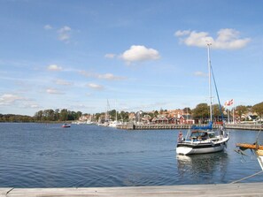 Ein Yachthafen mit vertäuten Booten, ein klarer Himmel und Gebäude im Hintergrund.