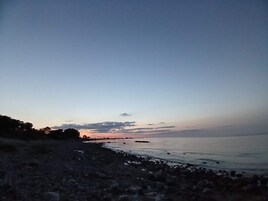 Una playa con costa rocosa y agua tranquila.