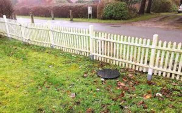 A white picket fence, a grassy area, and a road.