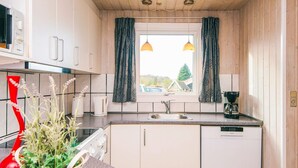 A compact kitchen with a window, a sink, a coffee maker, and a potted plant. - 4 Star Holiday Home in Nordborg (Nordborg)