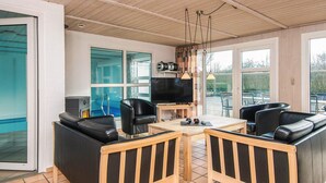A modern living room with a pool view, a TV, and comfortable seating. - 4 Star Holiday Home in Nordborg (Nordborg)