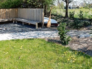A garden area with a wooden bench, a small plant, and a paved walkway. - 4 Star Holiday Home in Nordborg (Nordborg)