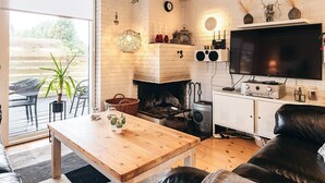 Ein gemütliches Wohnzimmer mit Kamin, Fernseher und Essbereich.