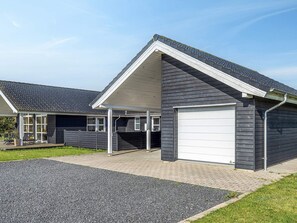A modern two-story house with a garage, a covered patio, and a driveway.