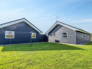 A two-story building with a sloped roof and a small front yard. - 5 Star Holiday Home in Hadsund (Hadsund)