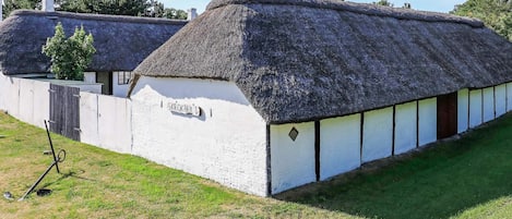 A traditional thatched-roof building with a sign reading 'SKROKHULT'.
