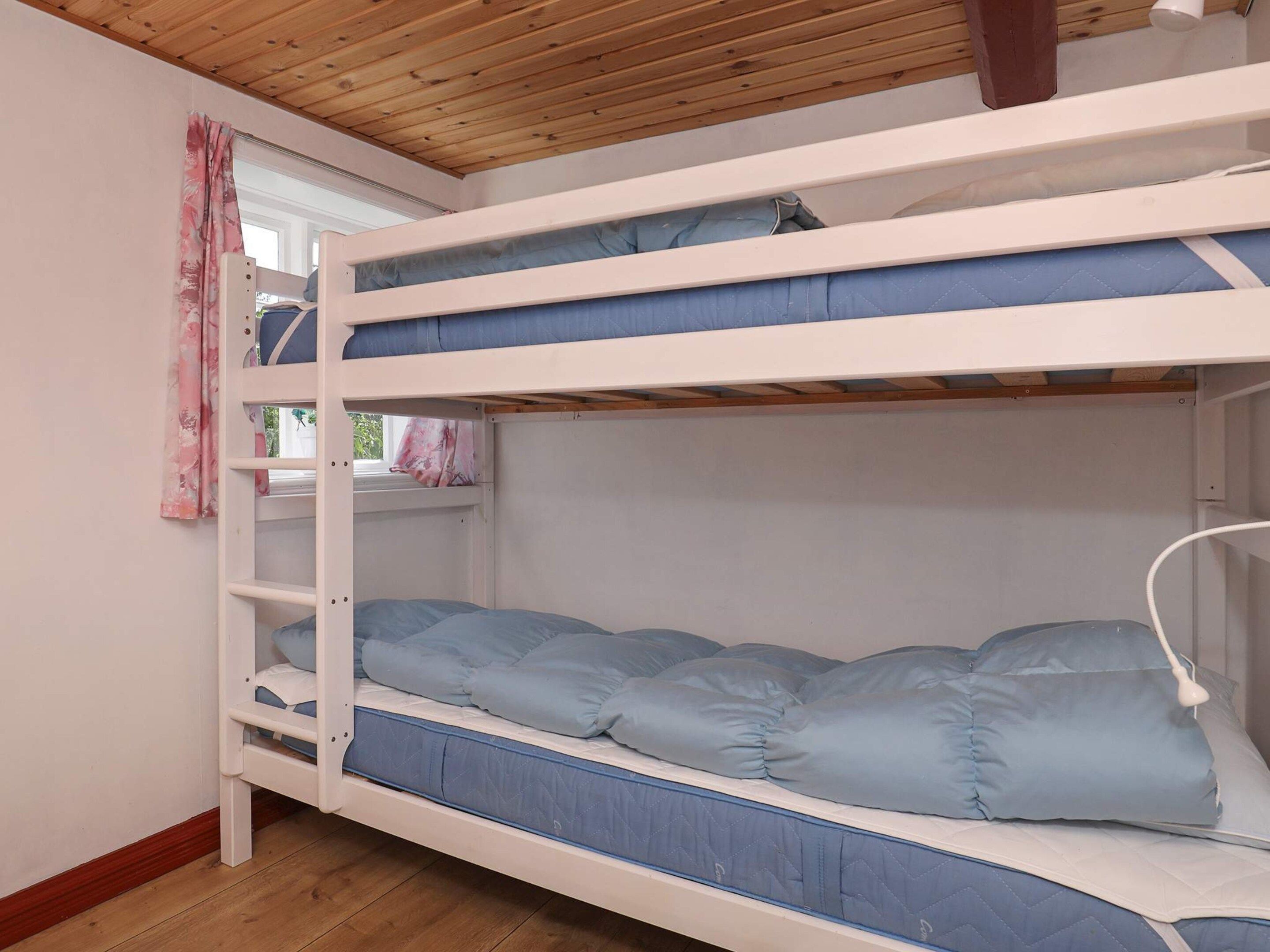 Een stapelbed met twee verhoogingen, elk voorzien van een matras en kussens.