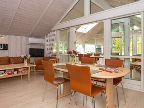 Un intérieur moderne comprenant un coin repas, un canapé et un téléviseur.