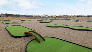 A miniature golf course with multiple green putting areas and a clear sky. - 9 Person Holiday Home in Brovst (Brovst)