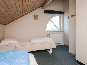 A bedroom with a single bed, a window with a view, and a radiator.