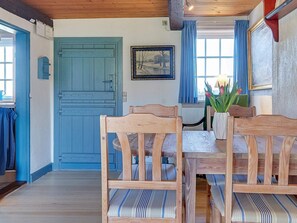 Traditional room with a dining table, striped chairs, and a vase with tulips.