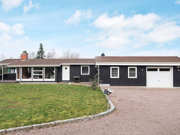 A two-story house with a garage, a covered porch, and a well-maintained lawn.